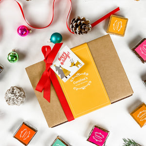 Gift box with a red ribbon and Christmas-themed cards on a white background