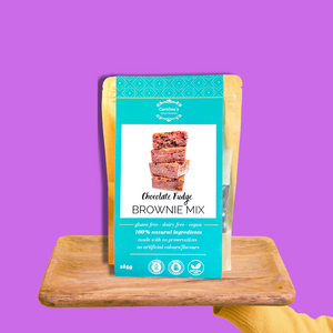 Package of chocolate fudge brownie mix on a wooden stand with a purple background