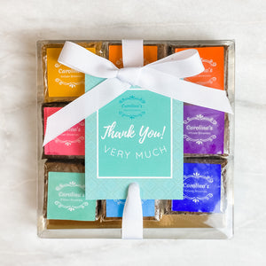 A gift box of assorted gourmet brownies from Carolina's Brownies, packaged in a clear box with a white ribbon and a 'Thank You' card.
